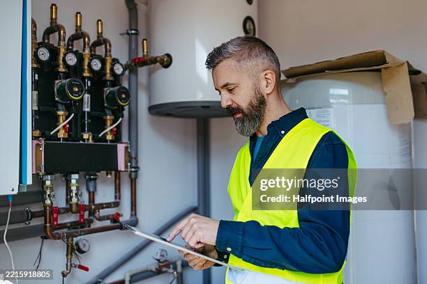 technician inspecting circulation pumps for underfloor heating system. - heizungsmonteur stock-fotos und bilder