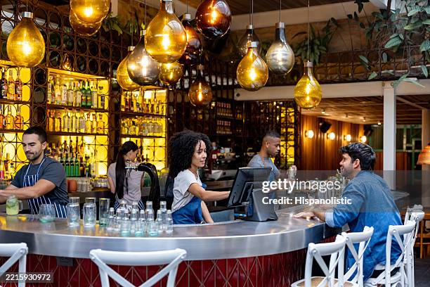 group of employees working at a bar and serving customers - waitress stock pictures, royalty-free photos & images