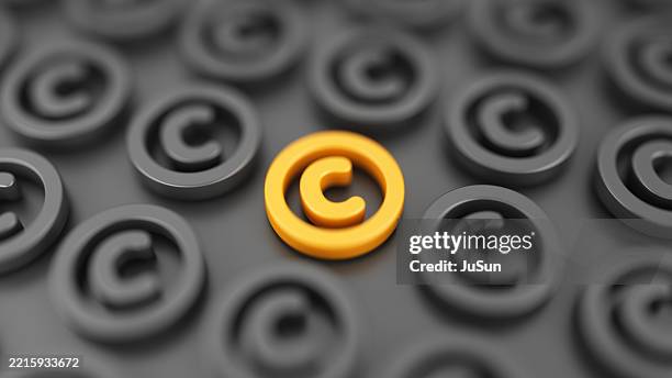 das leuchtend orangefarbene copyright-symbol hebt sich von einem muster aus dunklen symbolen, geistigem eigentum, rechteverwaltung und digitalem eigentum ab. - patenturkunde stock-fotos und bilder