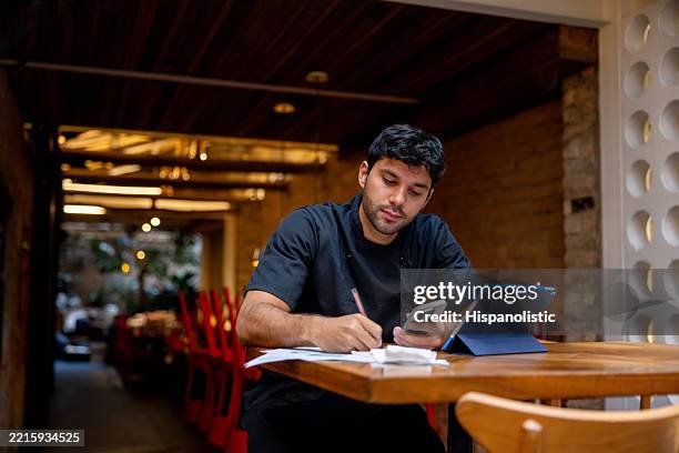 chef doing the accountancy at a restaurant - family business restaurant stock pictures, royalty-free photos & images
