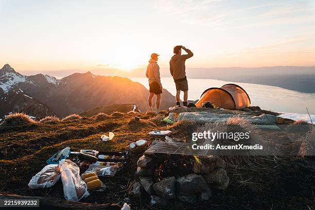 junge männer genießen den sonnenaufgang vom campingplatz auf dem berggipfel - selbstversorgung stock-fotos und bilder