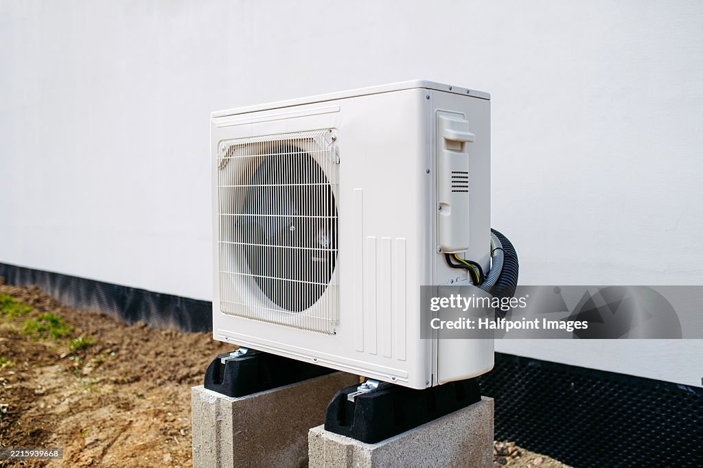 Outdoor heat pump unit next to the house.