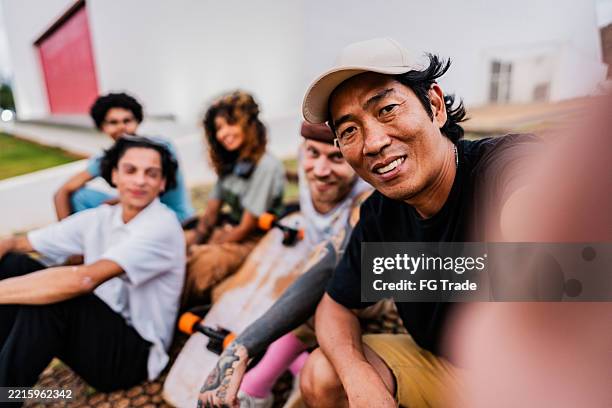 hombre maduro tomando una selfie con amigos en un parque público - punto de vista de una cámara fotografías e imágenes de stock