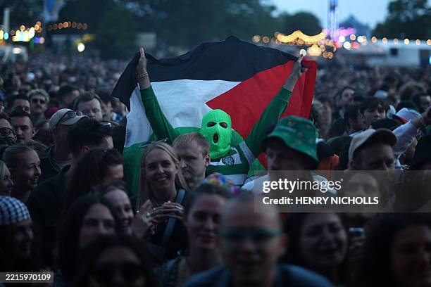 Festivalgoers hold Palestine flags as they wait to hear Northern Irish Hip Hop trio Kneecap perform onstage during Wide Awake Festival 2025 at...