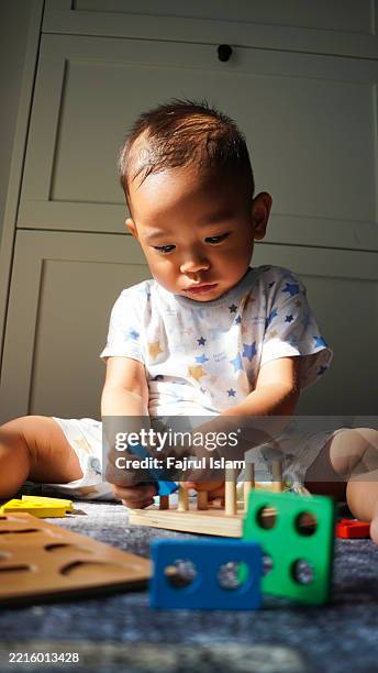 toddler playing with educational toys - achatar la curva de epidemia fotografías e imágenes de stock