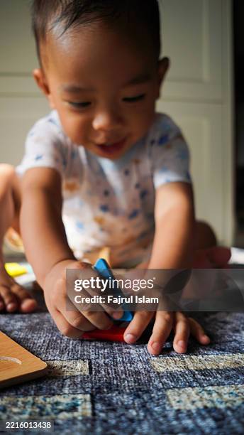 toddler playing with educational toys - achatar la curva de epidemia fotografías e imágenes de stock