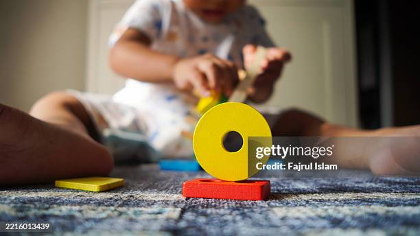 toddler playing with educational toys - achatar la curva de epidemia fotografías e imágenes de stock