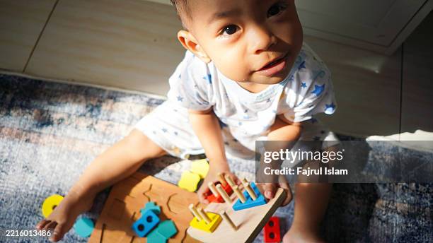 toddler playing with educational toys - achatar la curva de epidemia fotografías e imágenes de stock