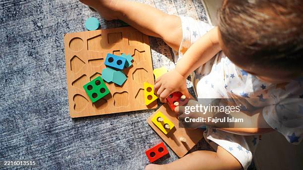 toddler playing with educational toys - achatar la curva de epidemia fotografías e imágenes de stock