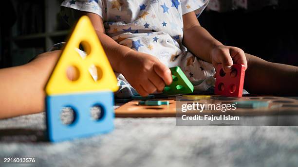 toddler playing with educational toys - achatar la curva de epidemia fotografías e imágenes de stock