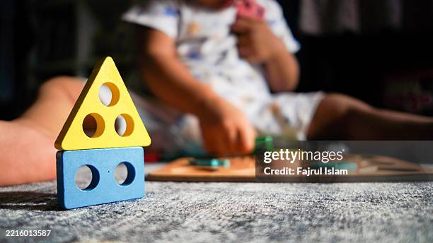 toddler playing with educational toys - achatar la curva de epidemia fotografías e imágenes de stock