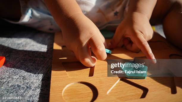 toddler playing with educational toys - achatar la curva de epidemia fotografías e imágenes de stock