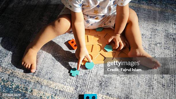 toddler playing with educational toys - achatar la curva de epidemia fotografías e imágenes de stock