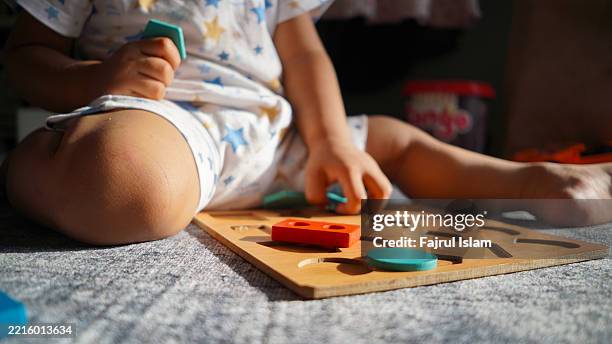 toddler playing with educational toys - achatar la curva de epidemia fotografías e imágenes de stock