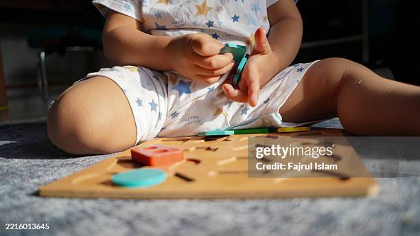 toddler playing with educational toys - achatar la curva de epidemia fotografías e imágenes de stock