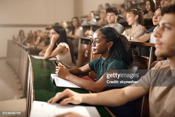 des étudiants universitaires assistant à un cours dans un amphithéâtre. - amphithéâtre photos et images de collection