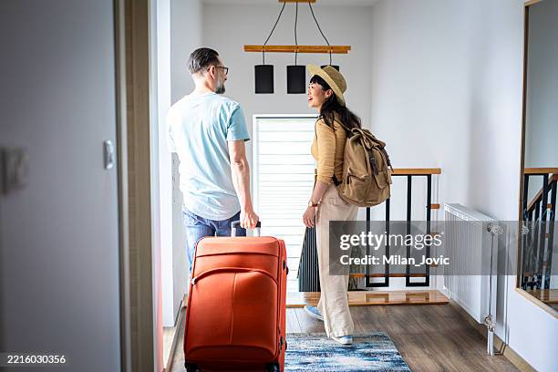 pareja caminando por el pasillo mientras tira de su maleta - motel pareja fotografías e imágenes de stock
