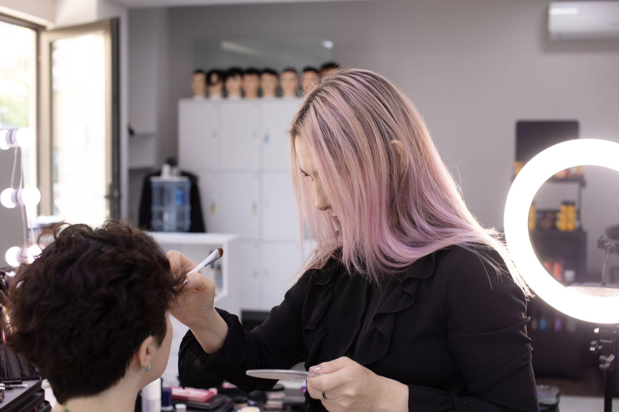 Professional beautician applying makeup on beautiful young woman's face. Professional beautician applying makeup on beautiful young woman's face.