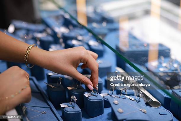 the female clerk in the jewelry store took out the jewelry on the counter and prepared to introduce it to the customers. - jewellery shop stock pictures, royalty-free photos & images