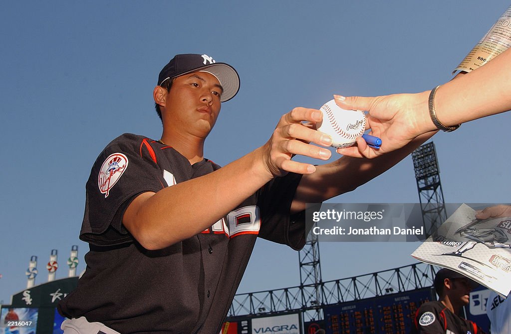 Chien-Ming Wang autographs a baseball