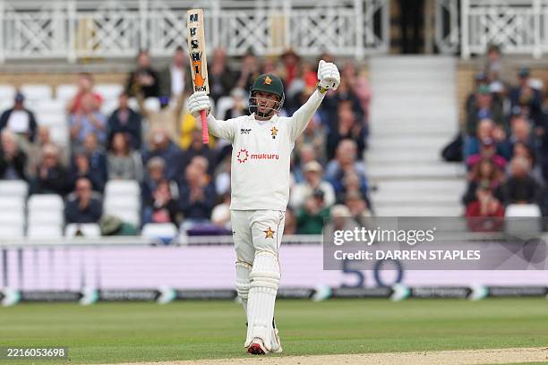 Zimbabwe's Sean Williams celebrates reaching his half century on the third day of the four day Test cricket match between England and Zimbabwe at...