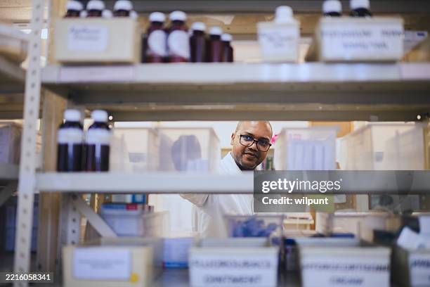 farmacéutico organizando medicamentos en una farmacia hospitalaria muy concurrida - material médico fotografías e imágenes de stock