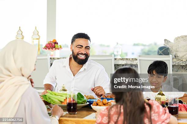 happy man laughing while having lunch with family - middle eastern food stock pictures, royalty-free photos & images