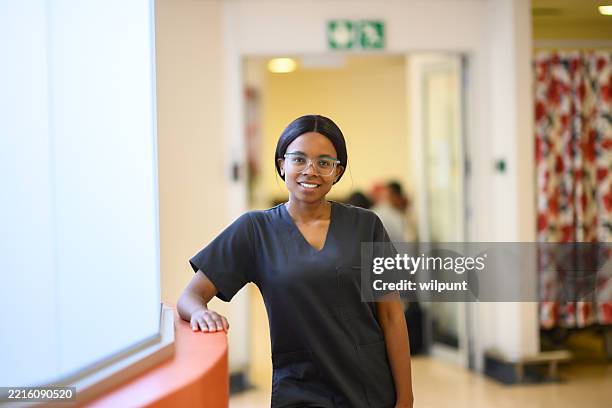 confident female medical student wearing scrubs in a hospital environment - public service stock pictures, royalty-free photos & images