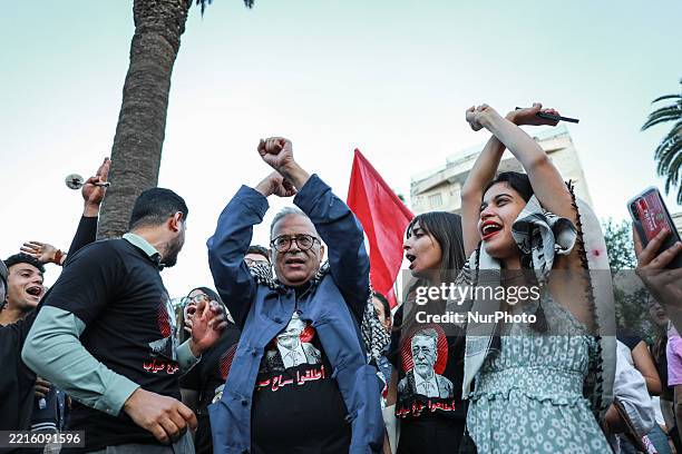 Demonstrators wave national flags of Tunisia and shout slogans during a symbolic visiting room organized by the family of lawyer and former judge...
