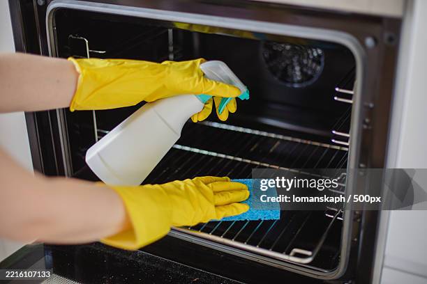 cropped hands of woman cleaning oven at home - ugn bildbanksfoton och bilder
