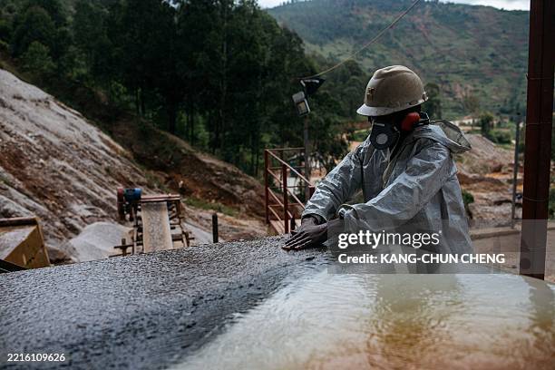 Worker sorts through minuscule cassiterite ore in a new cassiterite processing plant at a tin mine owned by Trinity Metals in Nyamyumba, on May 24,...