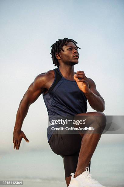 athletic man exercising on a scenic beach during a workout routine - milk run stock pictures, royalty-free photos & images