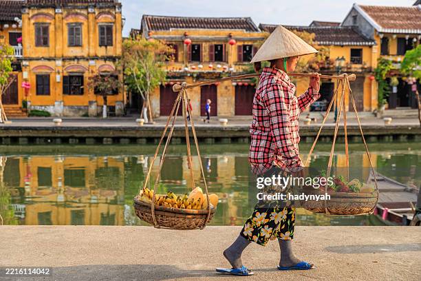 vietnamese woman selling tropical fruits, old town in hoi an city, vietnam - hoi an stockfoto's en -beelden