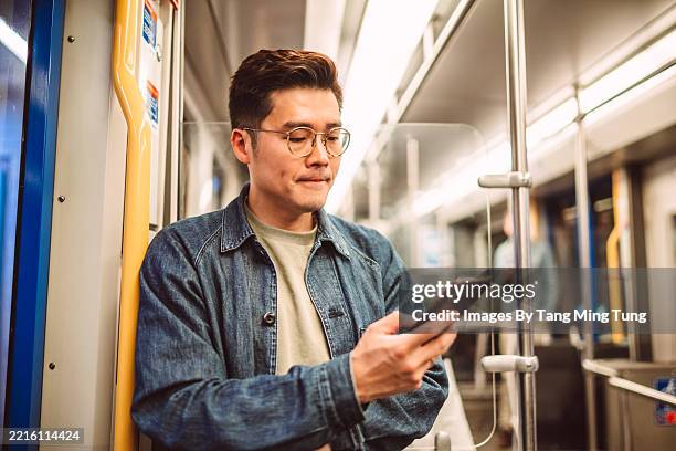 confident man using smart phone on public transport - day in the life series stock pictures, royalty-free photos & images