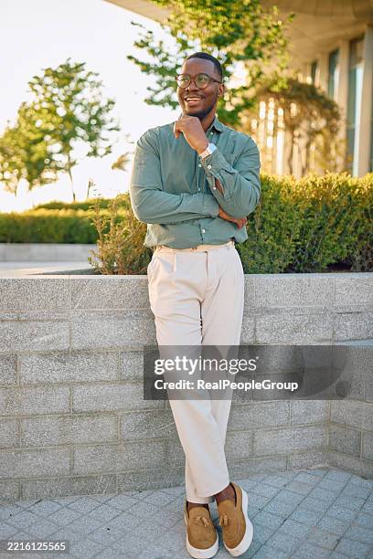 homme d’affaires souriant debout avec les bras croisés dans une ville moderne - représentation masculine photos et images de collection