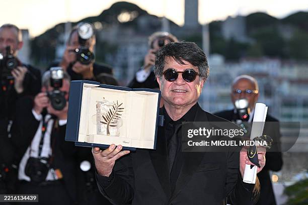 Iranian director and screenwriter and producer Jafar Panahi poses with the trophy during a photocall after winning the Palme d'Or for the film "Un...