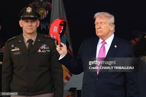 President Donald Trump removes his hat as he departs after delivering the commencement address at the 2025 US Military Academy Graduation Ceremony at...