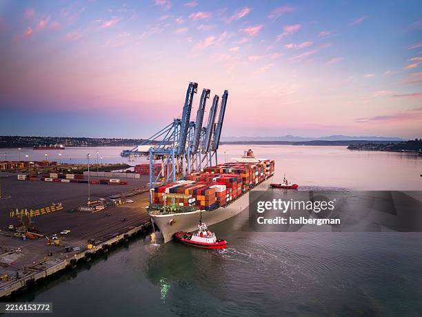 drohnenaufnahme eines frachtschiffs, das bei sonnenaufgang am containerterminal in tacoma, wa, geparkt ist - schiff stock-fotos und bilder