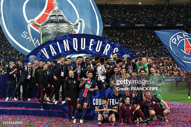 S players pose with the trophy after winning the French Cup final football match between Paris Saint-Germain and Stade de Reims at the Stade de...