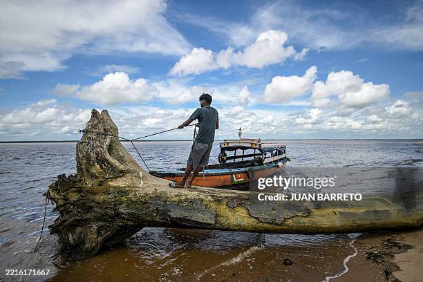Fisherman works on a boat at the shores of Braamspunt Island in Paramaribo on May 24, 2025. Suriname, South America's smallest country, is preparing...
