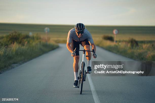 professional cyclist sprinting on the road at sunset. - cyklist bildbanksfoton och bilder