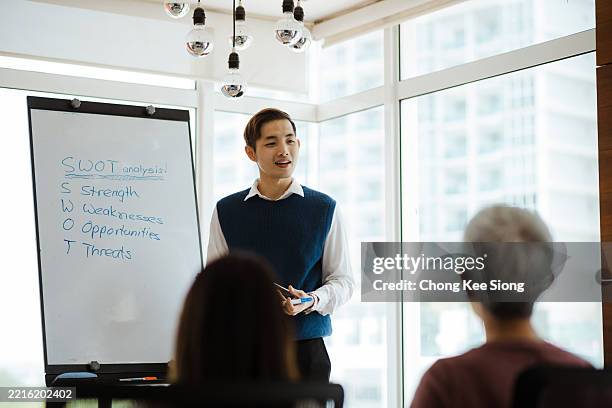 office leader giving strategy briefing with swot diagram - swot analysis stock pictures, royalty-free photos & images