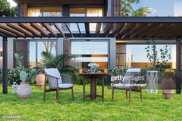 exterior de villa moderna con mesa de centro y sillas en el jardín - terraza fotografías e imágenes de stock