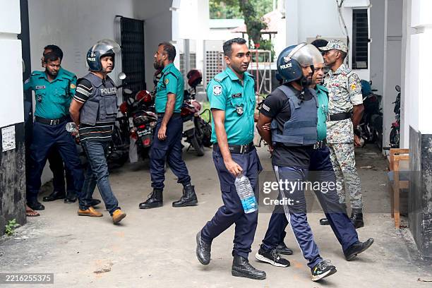 Police personnel escort detained policemen charged with crimes against humanity, to the International Crimes Tribunal court in Dhaka on May 25, 2025....