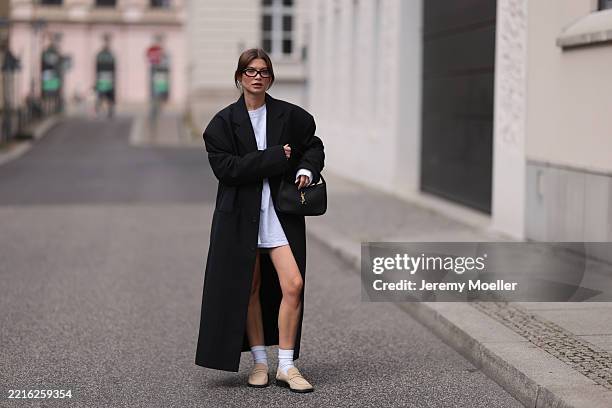 Sophia Geiss is seen wearing silver hoop earrings in two different sizes; oval brown glasses from Corlin; a silver nose ring; an oversized,...