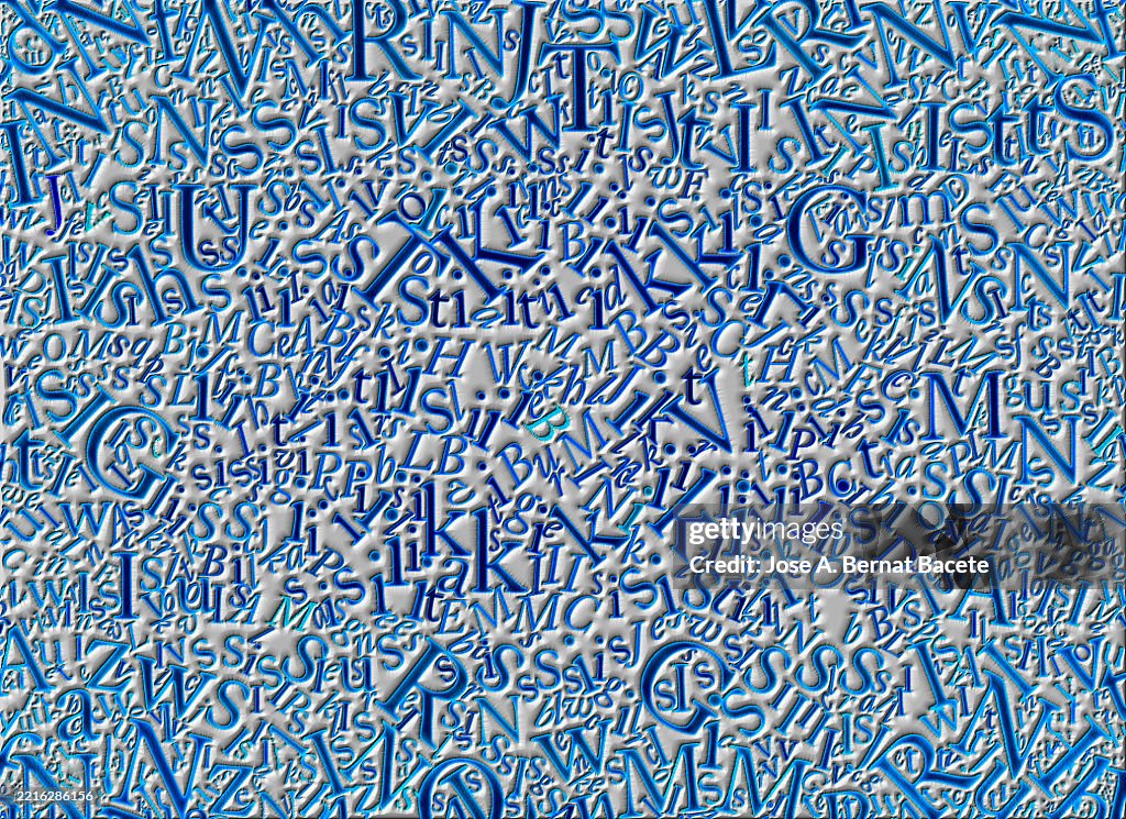 Abstract background, jumbled embossed alphabet letters on a gray background.