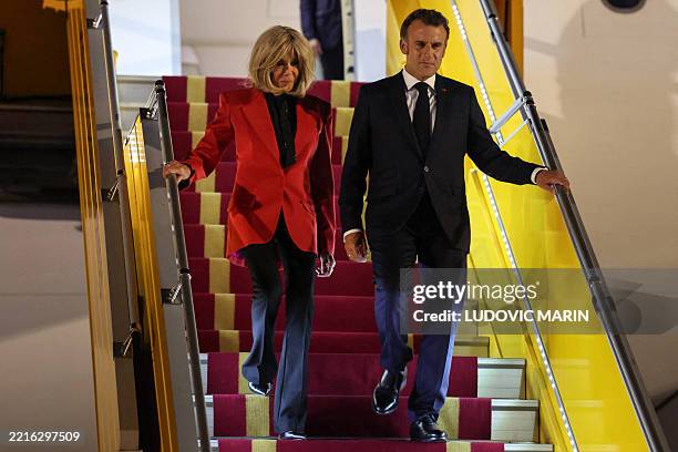 France's President Emmanuel Macron and his wife Brigitte Macron disembark from the plane upon their arrival at Noi Bai International Airport in Hanoi...