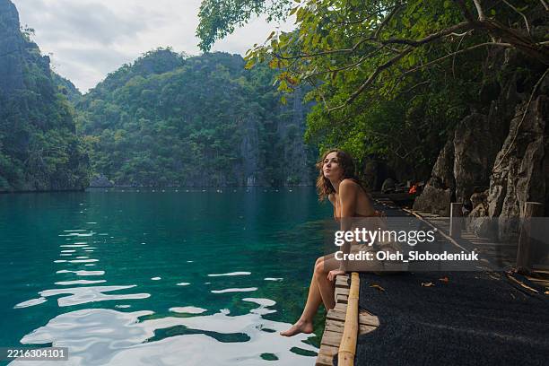donna che guarda la laguna maestosa e il lago baraccuda a coron, filippine - filippino foto e immagini stock