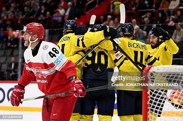 Denmark's defender Nicholas Jensen looks on as Sweden's forward Marcus Johansson celebrates with teammates after scoring the 5-2 goal during the IIHF...