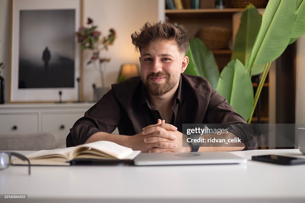 Man Writing in a Notebook at a Desk